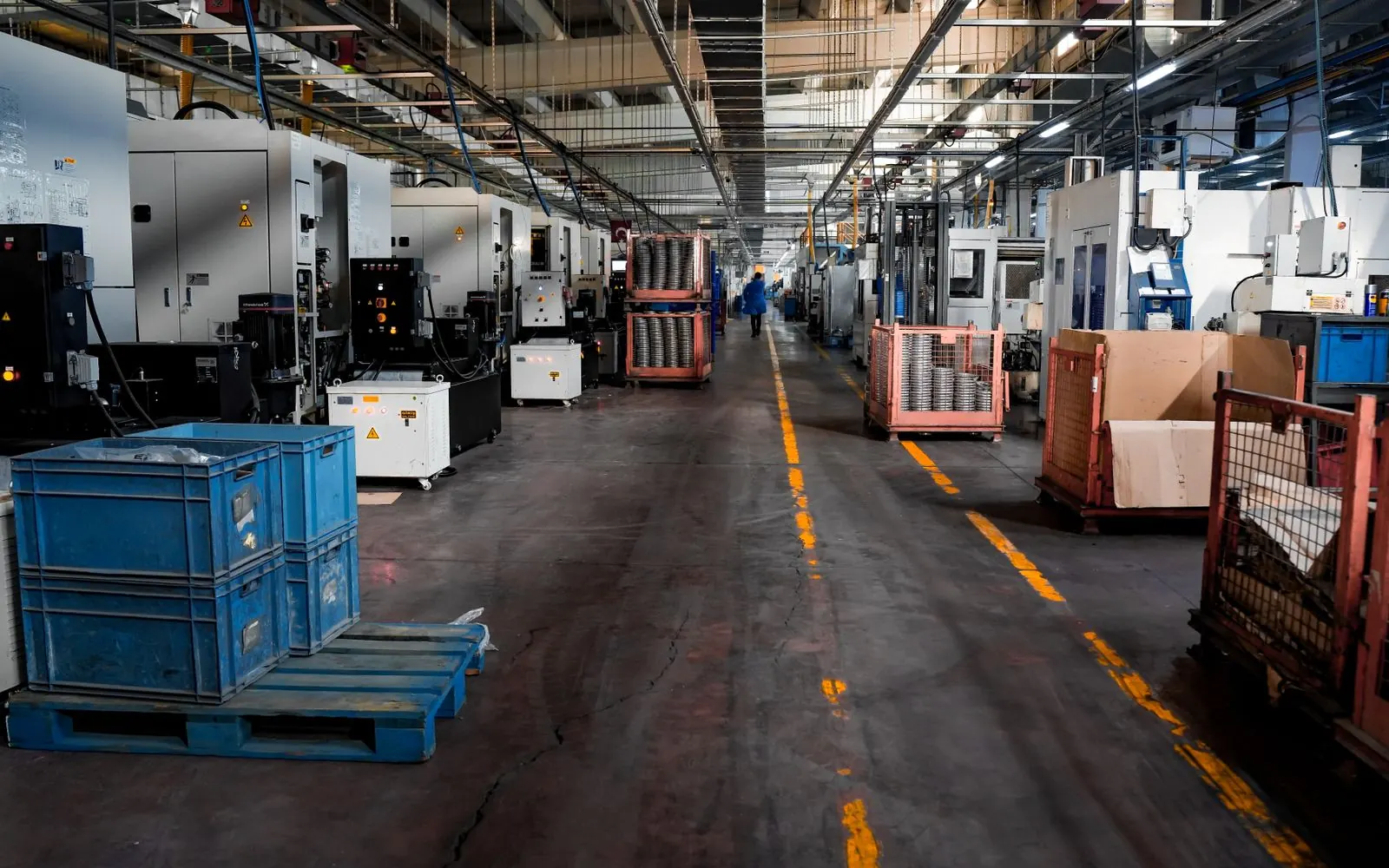 Factory floor with machinery and crates along a marked walkway